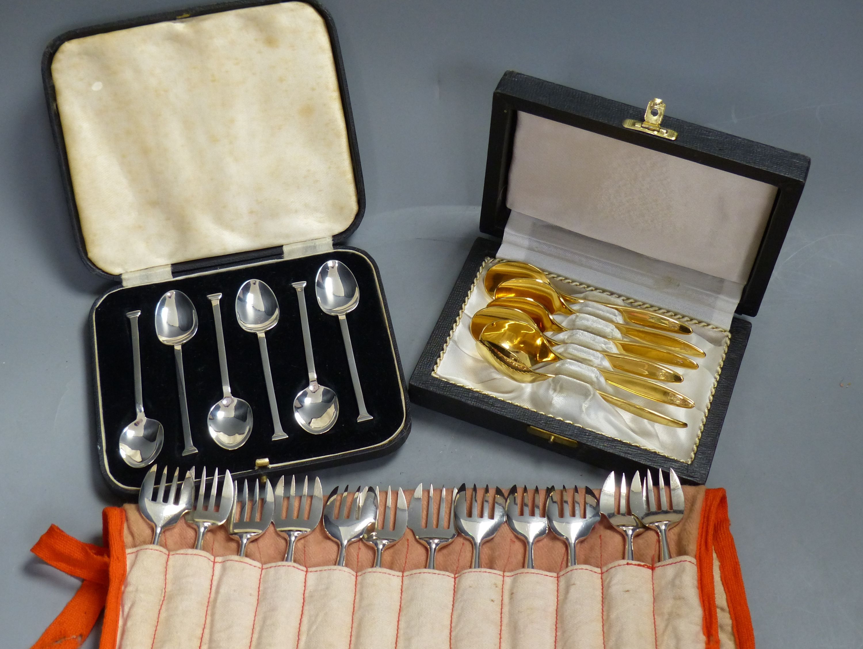 A set of twelve Christofle forks, a cased set of English coffee spoons and a set of Solingen gold-plated spoons.
